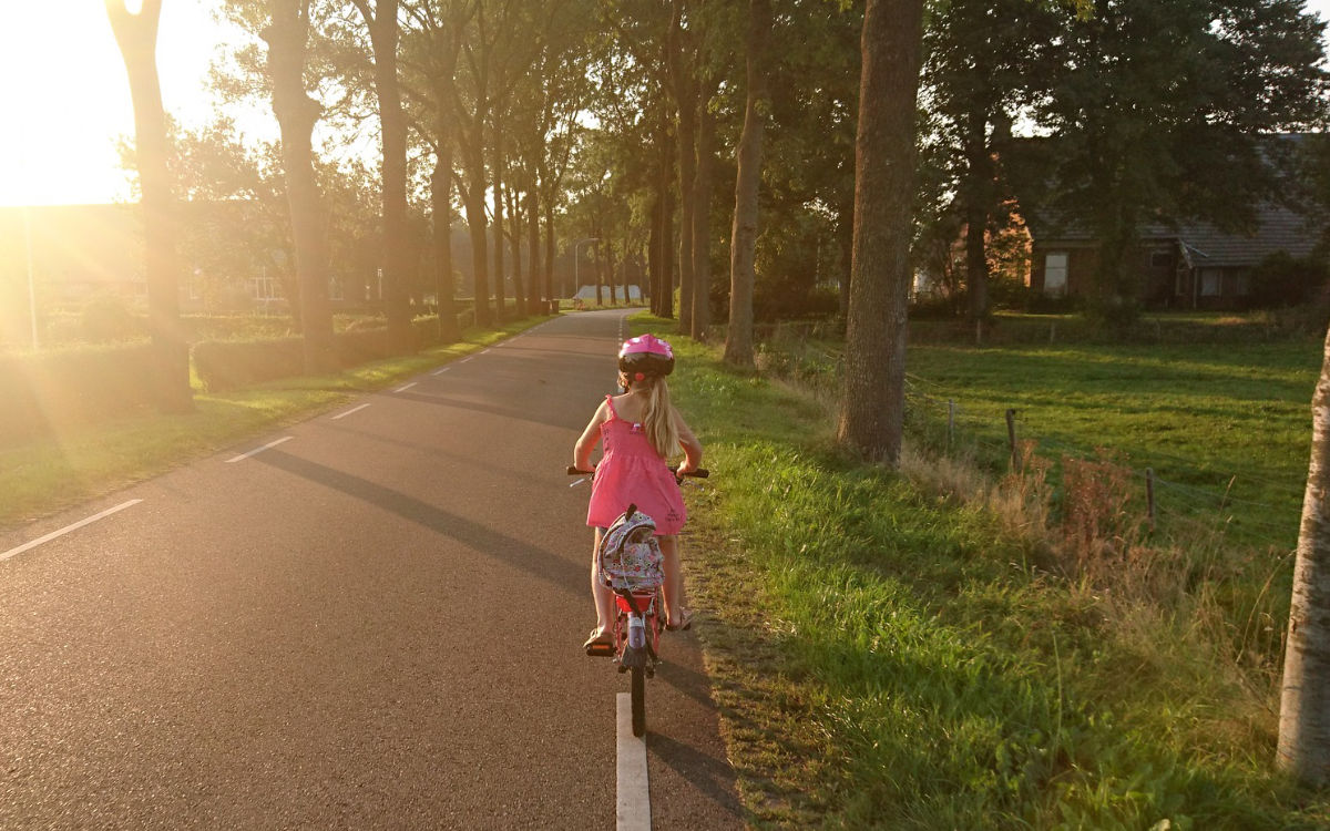 Ein Mädchen fährt mit dem Fahrrad auf der Straße. Foto: pixabay