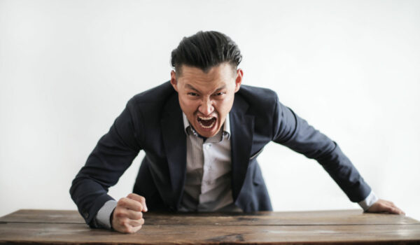 Ein Mann haut wütend mit der Faust auf den Tisch. Foto: Pexels