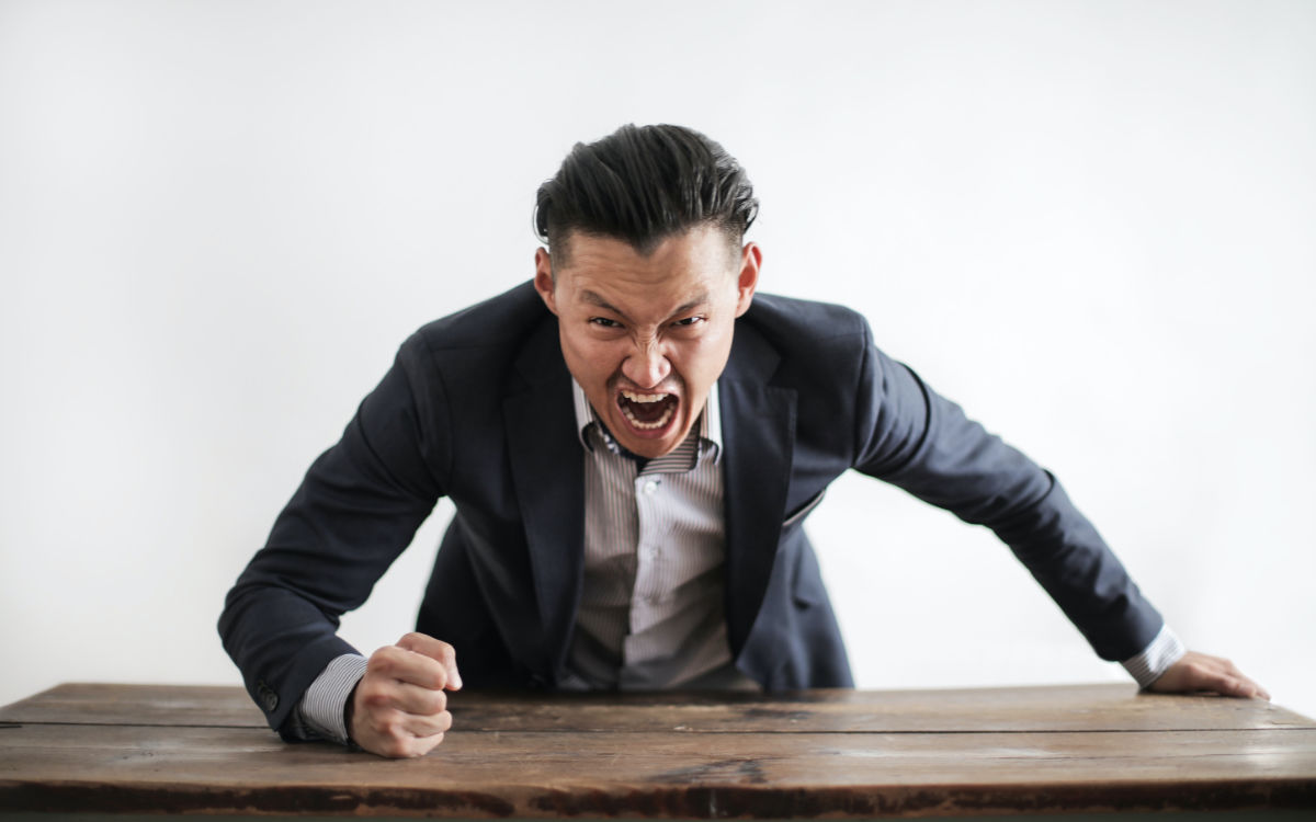Ein Mann haut wütend mit der Faust auf den Tisch. Foto: Pexels