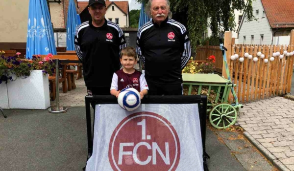Der 1. FC Nürnberg hat dem kleinen Ryan Hacker aus Bayreuth ein Geschenk überreicht. V.l.n.r.: Bernd Reindl, Camp-Leiter 1. FCN, Ryan Hacker und Klaus 