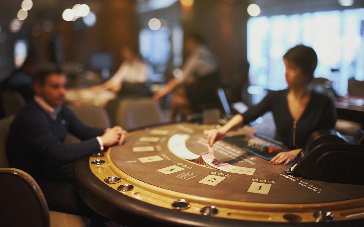 Ein Croupier mischt Karten an einem Blackjack-Tisch
