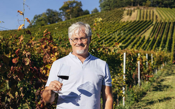 Markus Bruker in einem seiner Weinberge mit einem Glas Rotwein – natürlich einer seiner Weine ð - Fotos © Weingut Bruker