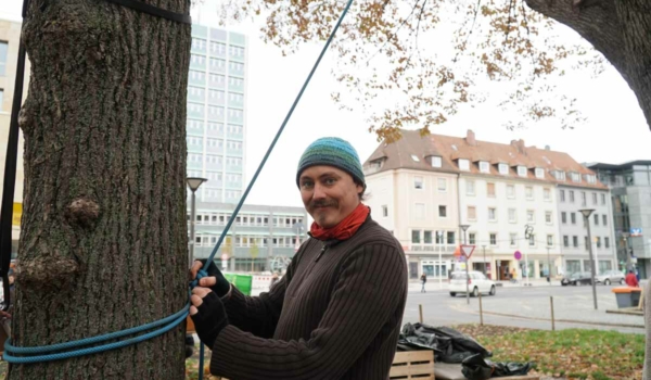 Der Bayreuther Aktivist Thomas Lachner spannte am frühen Nachmittag mit seinen Mitstreitern die ersten Seile gegenüber vom Bayreuther Rathaus. Foto: Johannes Pittroff