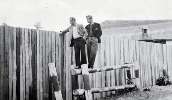 1952: Zwei Männer blicken über den kurz zuvor erbauten Holzbretterzaun in die DDR © Museum Mödlareuth ׀ Foto: Friedrich Marx