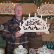Händler Tom Neupert aus Thüringen verkauft neben Bonbons auch noch Schwibbögen auf dem Bayreuther Weihnachtsmarkt. Foto: Johannes Pittroff