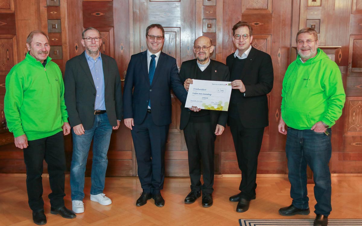 Regierungspräsident Florian Luderschmid (3.v.l.) übergibt den symbolischen Spendenscheck an Dekan Jürgen Hacker und Pfarrer Christian Karl Steger für die Initiative 