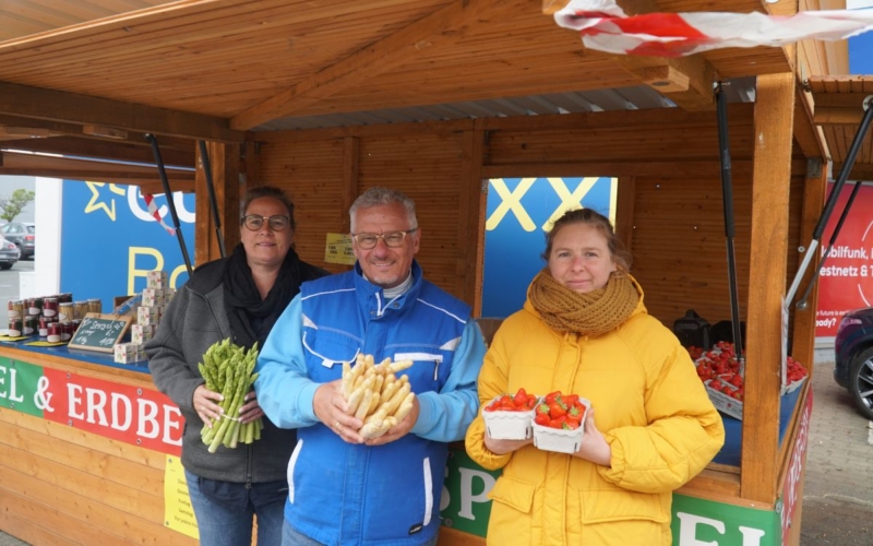 Katja Kulka-Schmidt (v. li.), Markus Kulka und Verkäuferin Rebecca Batsch bieten weißen und grünen Spargel sowie Erdbeeren an. Foto: Hans Koch