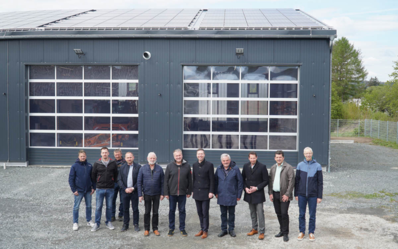 Landrat Florian Wiedemann (M.) feiert gemeinsam mit den am Projekt Beteiligten die Fertigstellung der neuen Solaranlage am Kreisbauhof Weidenberg. Foto: Stefanie Schweinstetter